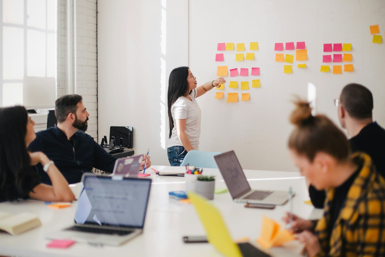 The team planning together at a whiteboard covered in sticky notes
